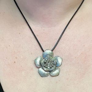 Large SILVERTONE flower pendant with black satin cord.